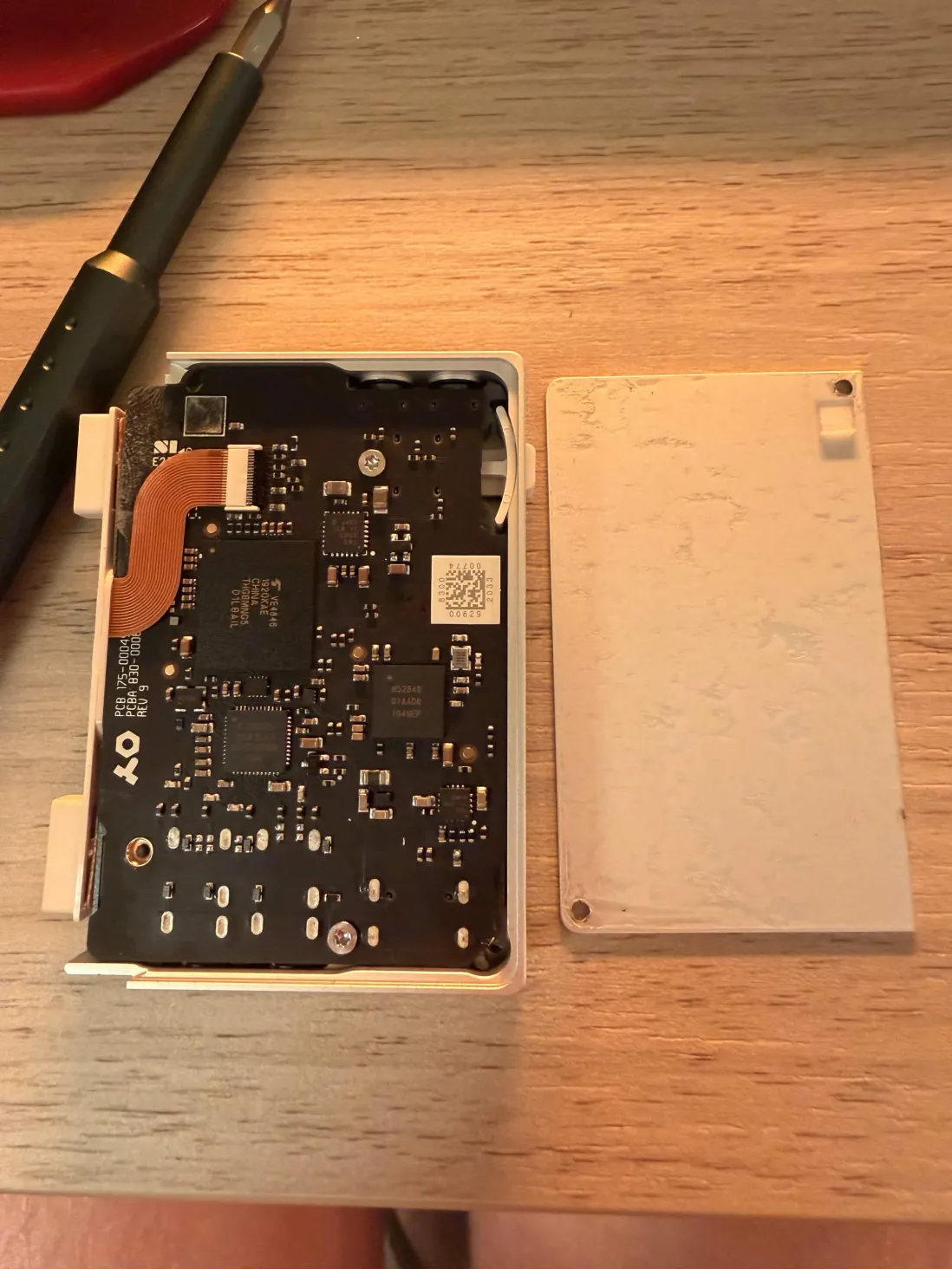 Back plate removed, exposing the main board with nRF52840 and eMMC